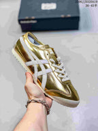 Metallic gold low-top sneaker with pale side stripes and white laces