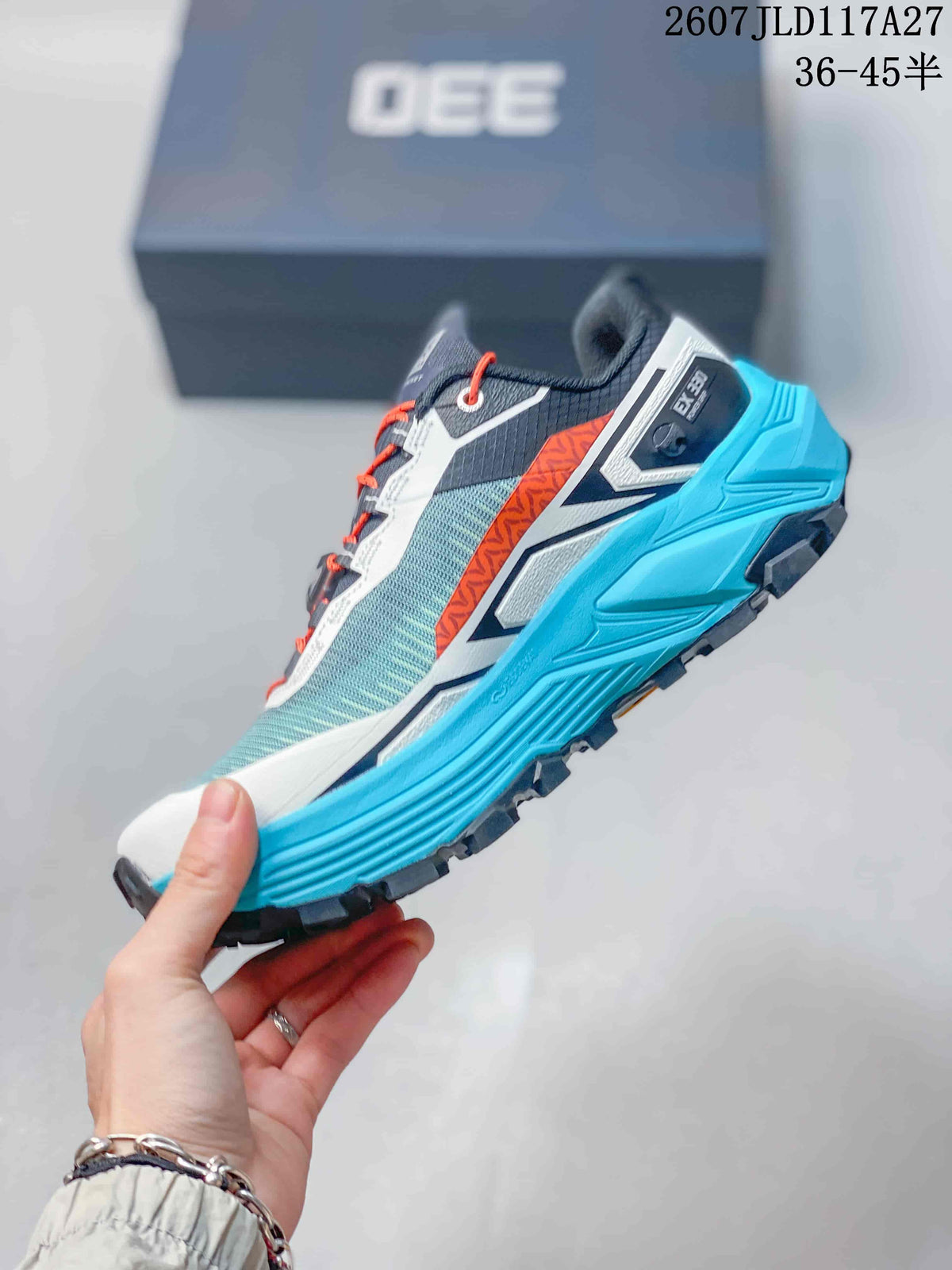 Side view showing the teal midsole, patterned upper, orange accent panel, and lugged outsole.