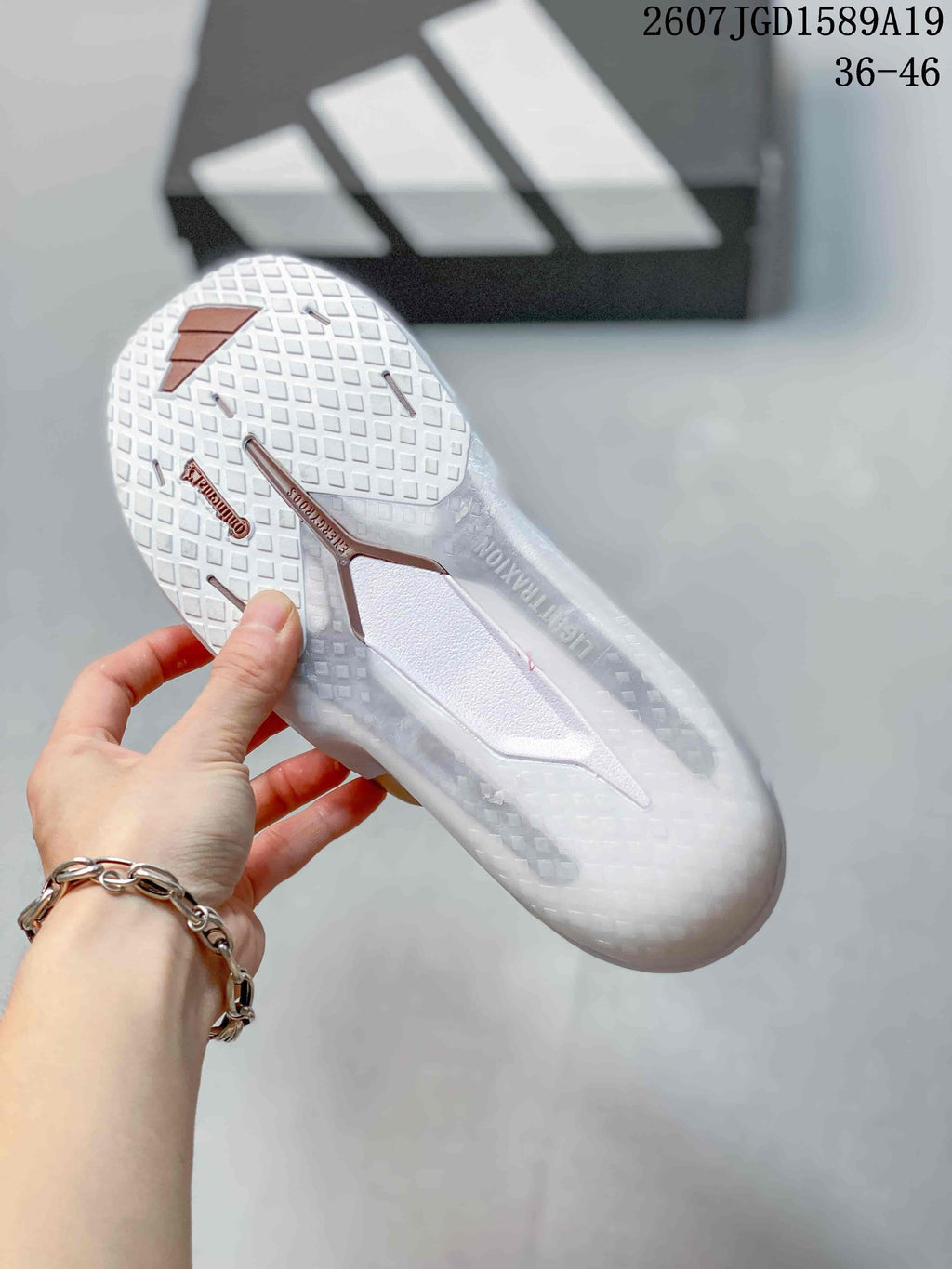 Underside view of the white sneaker showing the textured outsole and copper-colored outsole details; image text indicates 36–46.