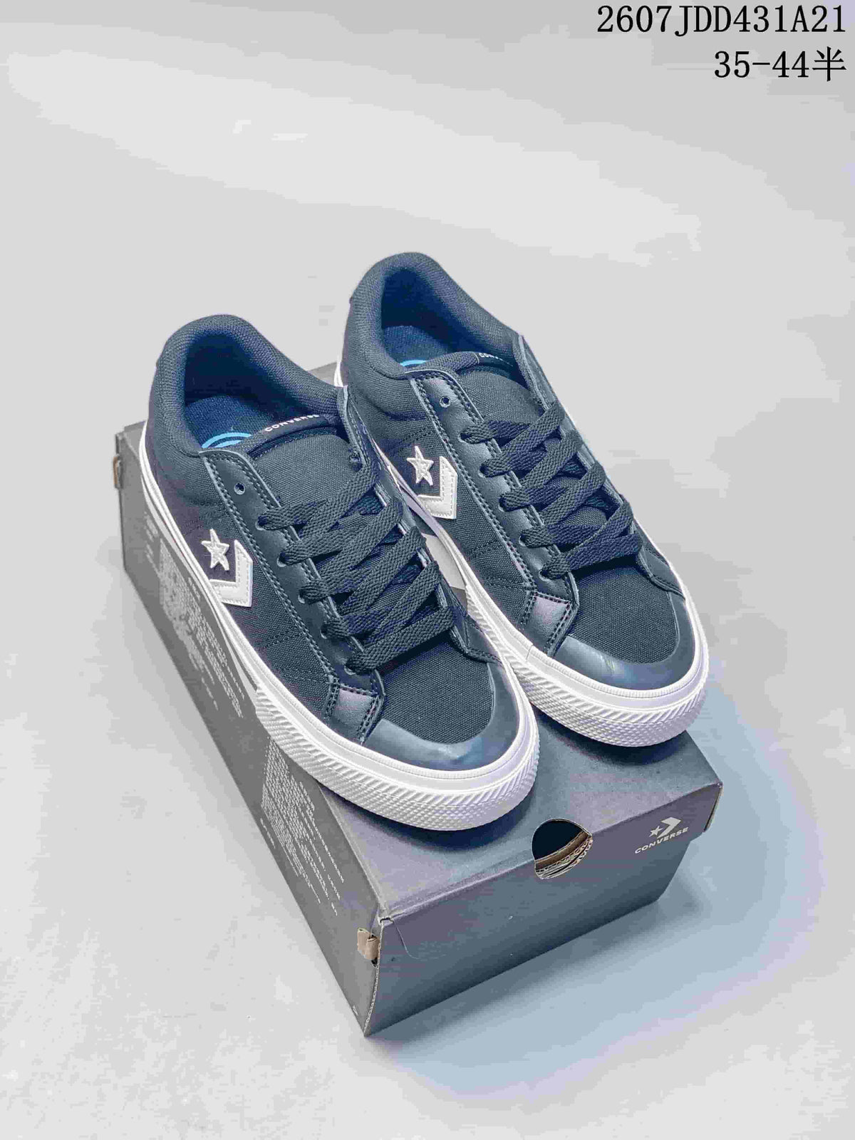 Pair of navy Converse low-top sneakers displayed on a Converse shoebox, showing white side branding and white rubber outsoles.