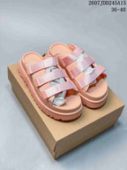 Pink UGG GoldenGlow slide sandals with three light pink adjustable straps displayed on a box.