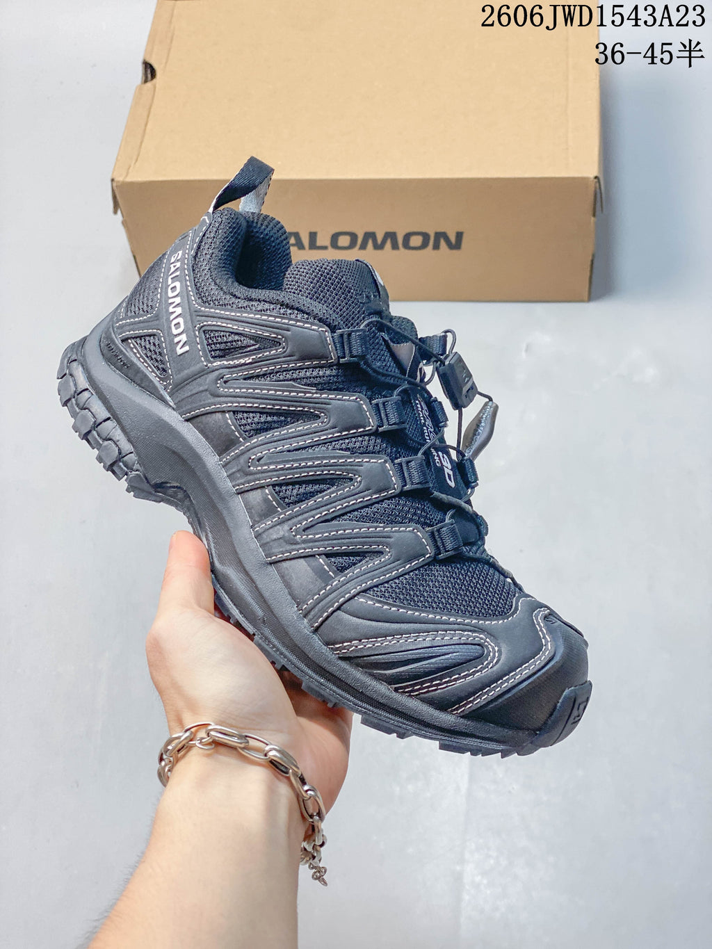 Angled side view of a dark Salomon shoe with mesh-like panels and a rugged outsole; image overlay lists sizes 36–45.5.