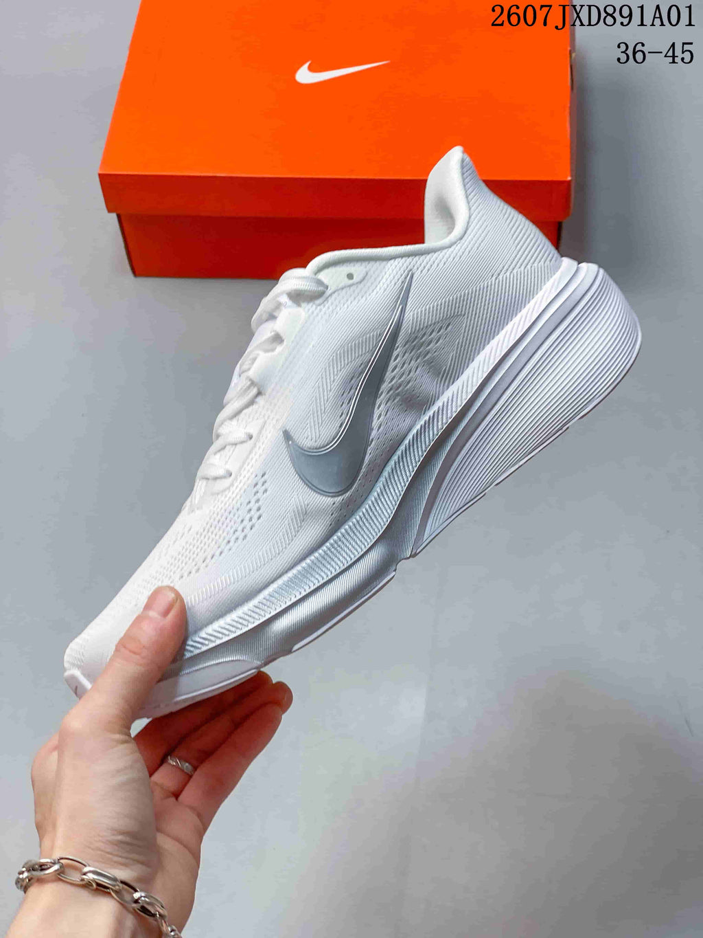 Side view of the white running shoe with silver-tone side logo