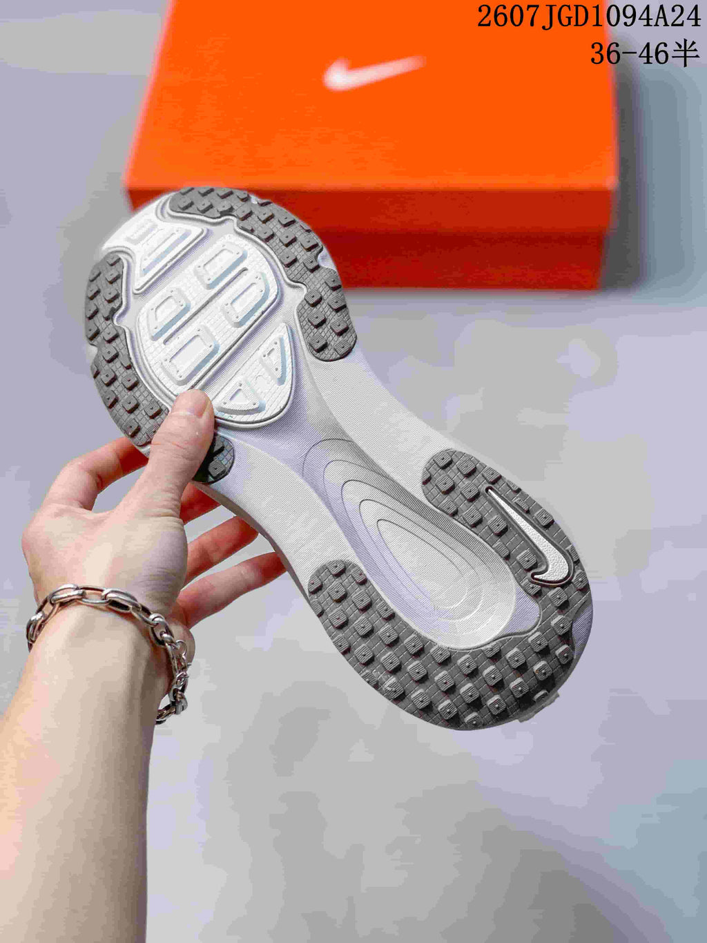Close view of the sneaker outsole showing segmented rubber tread and a central patterned section.