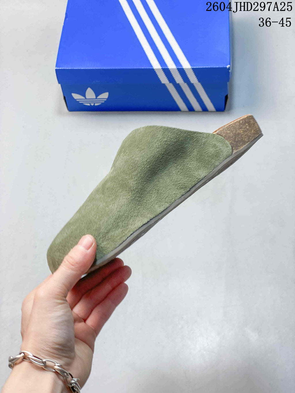 Side profile of the green Adidas Adimule slide showing the covered upper, contoured footbed and layered sole.
