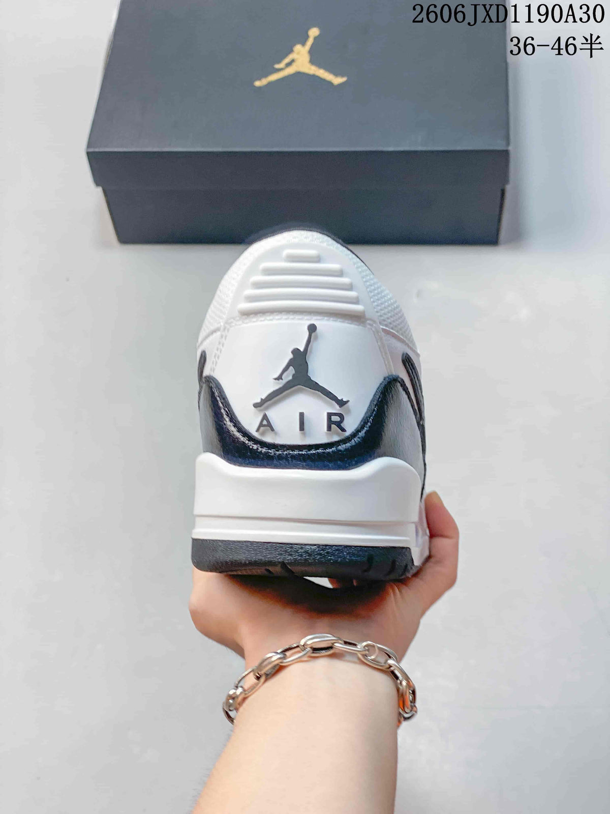 Rear view of a white and dark Jordan Legacy 312 Low sneaker