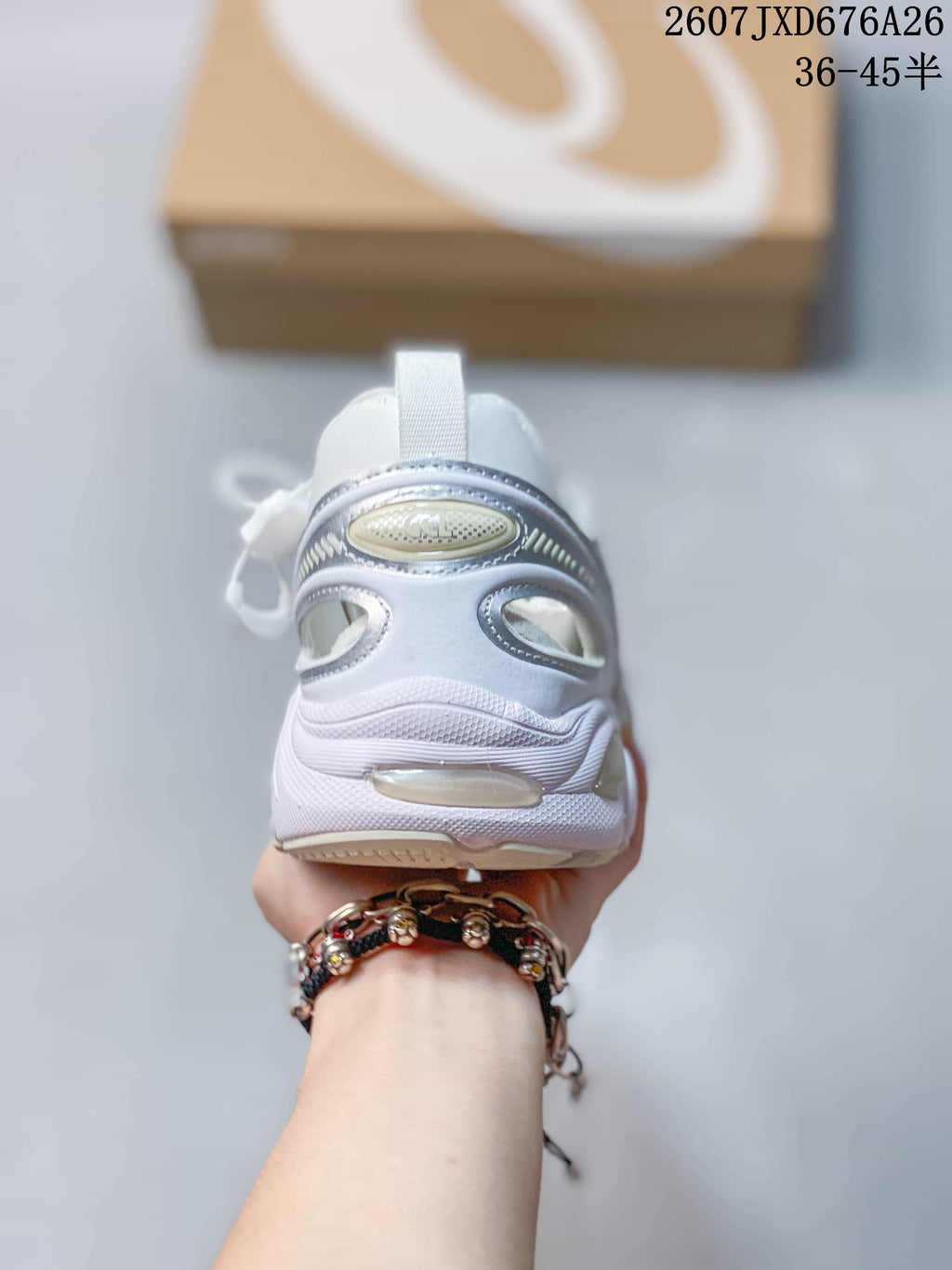 Rear view of the sneaker showing the padded heel, pull tab, layered heel structure, and outsole details.