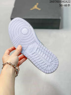 Underside of a light-colored sneaker showing a circular rubber outsole pattern and embossed branding.