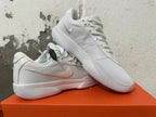 Pair of white Nike G.T. Cut Academy shoes shown from side and top angles