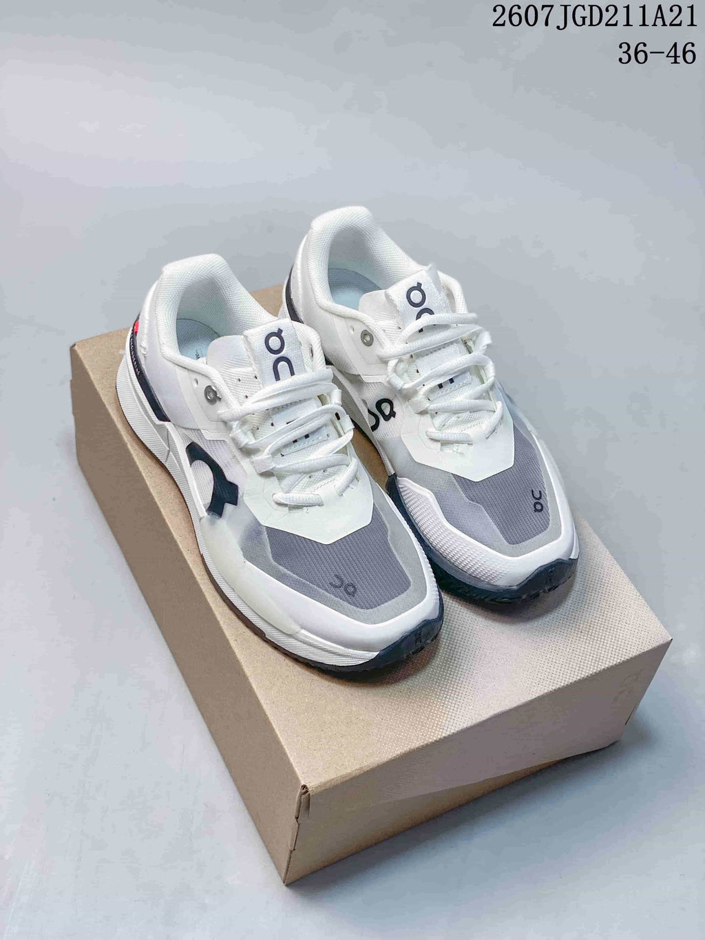 Pair of white, gray, and navy On THE ROGER Pro 2 sneakers displayed on a shoe box; model code and size range are visible above.