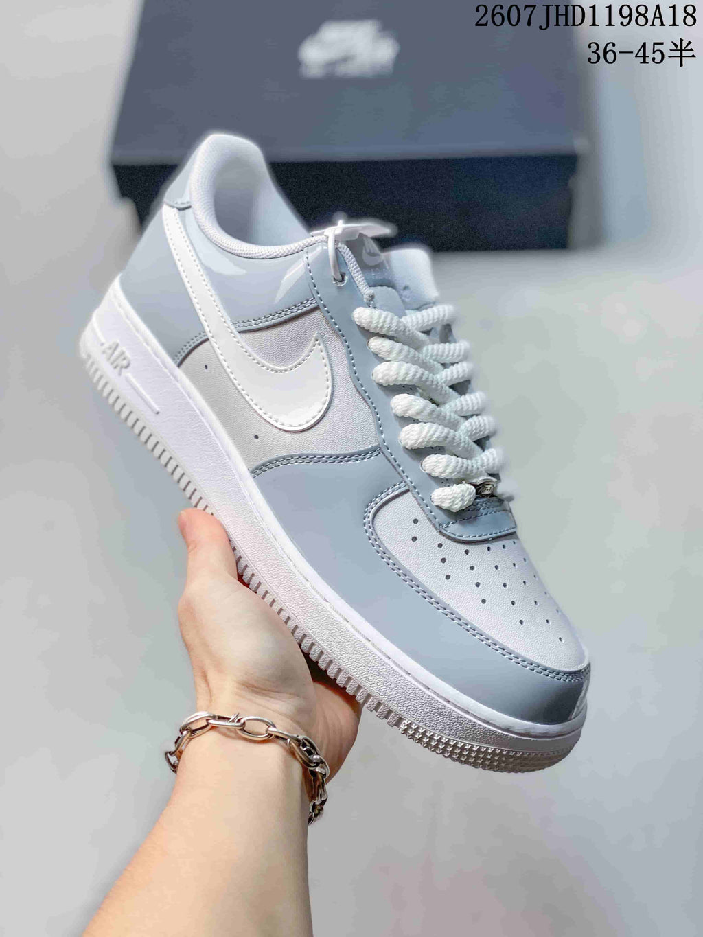 Angled side view of the gray and white low-top sneaker showing the Swoosh, heel panel, and outsole.