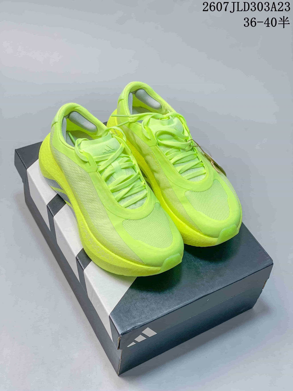 Pair of neon yellow-green Adidas HYPERBOOST EDGE W sneakers displayed on a shoebox.