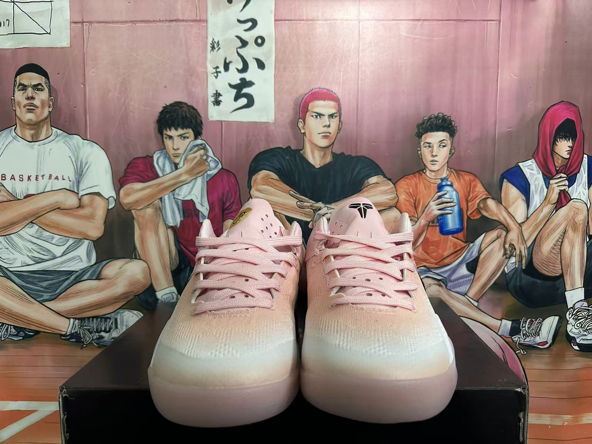 Front view of pink Nike basketball sneakers with matching laces and black tongue branding.