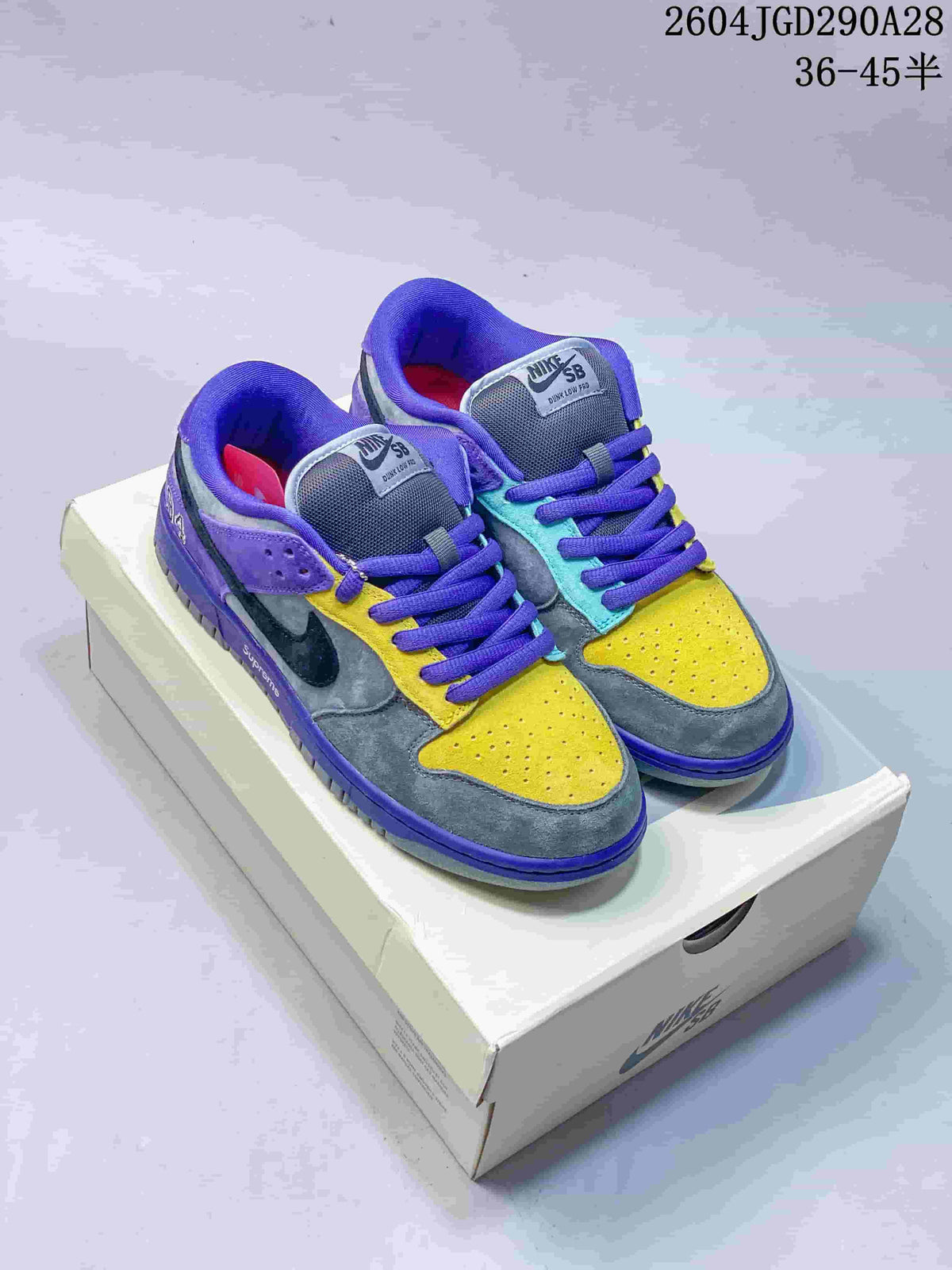 Pair of multicolor Nike Dunk Low SB-style sneakers on a shoebox
