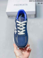 Top view of a navy trainer showing the white laces, padded blue collar and branded tongue.