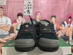 Front view of black lace-up Puma sneakers with grey toe accents