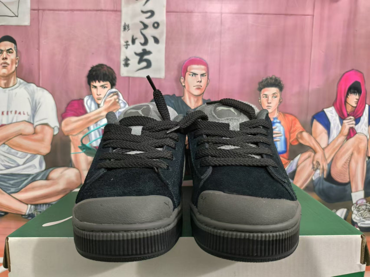 Front view of black lace-up Puma sneakers with grey toe accents