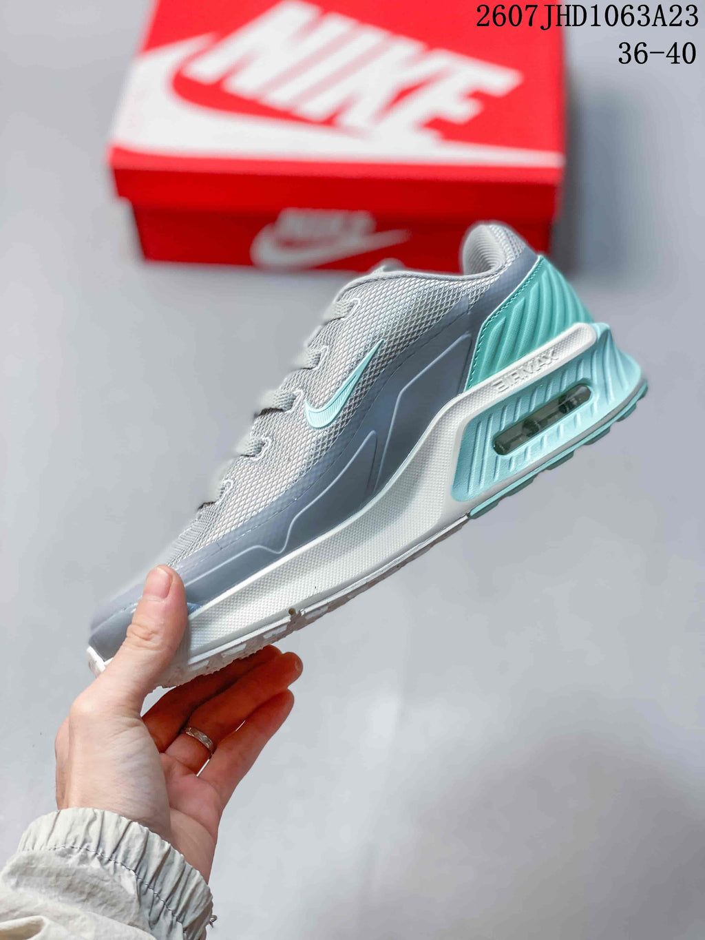 Side profile highlighting the gray upper, turquoise accents, layered midsole, and visible rear air unit.