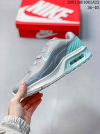 Side profile highlighting the gray upper, turquoise accents, layered midsole, and visible rear air unit.
