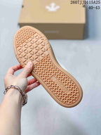 Close-up of the gum-colored outsole showing a geometric triangular tread pattern and DESCENTE branding.