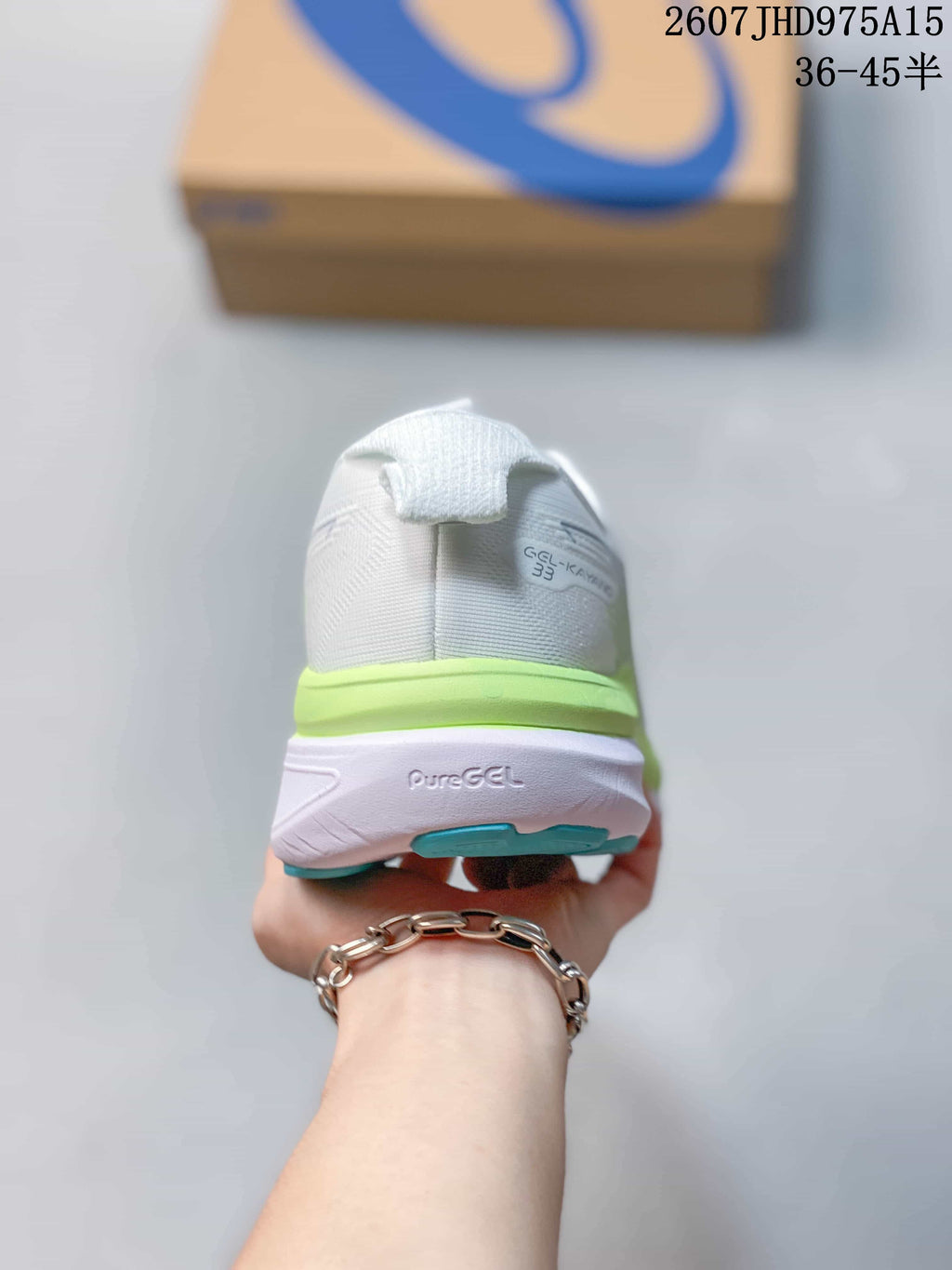 Rear view of the shoe showing the Gel-Kayano 33 heel marking, lime-green midsole, and turquoise outsole detail.