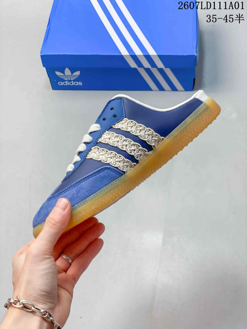 Side profile of the blue mule shoe with decorative chain-style stripes