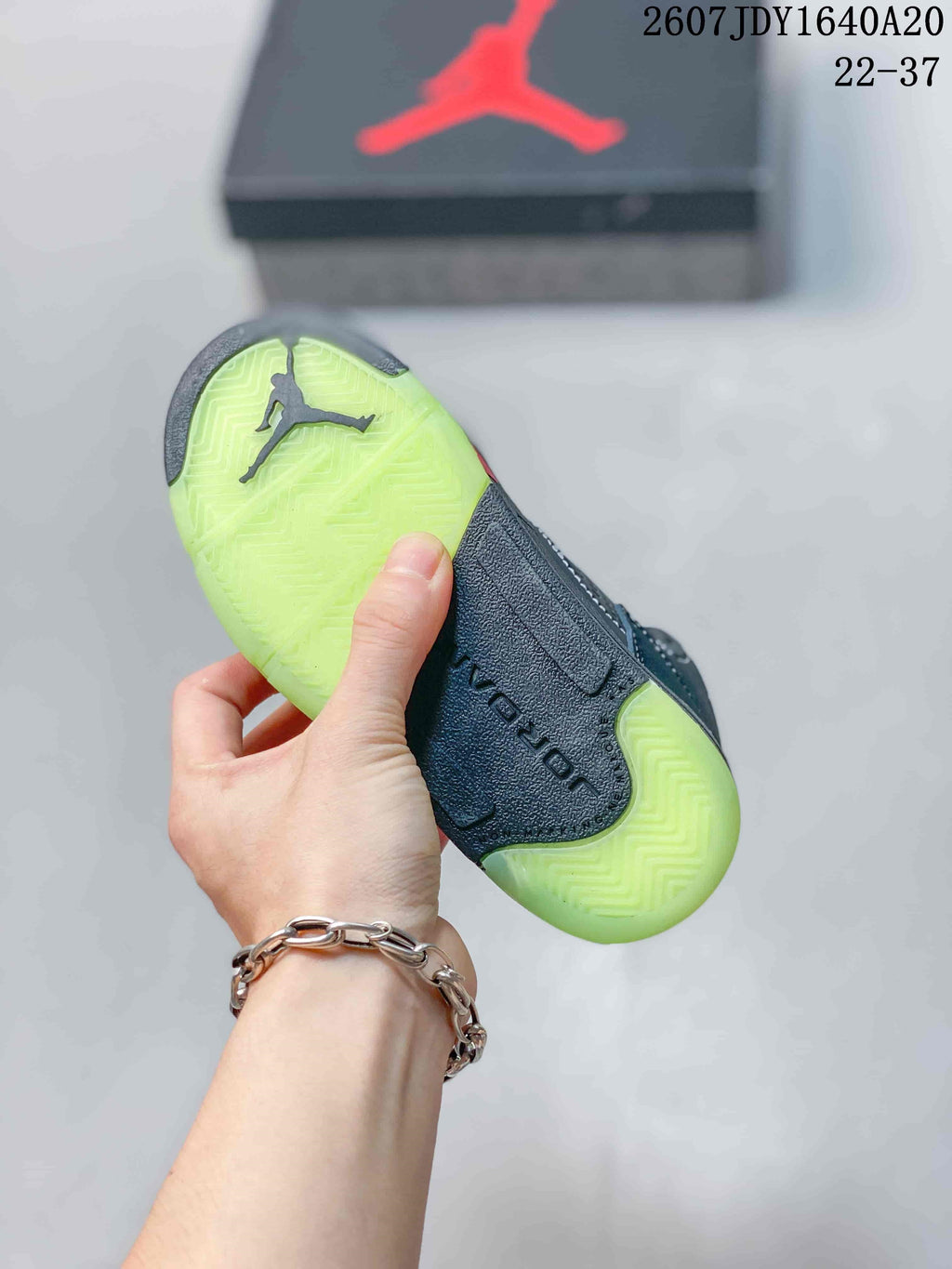Bottom view of a Jordan sneaker showing the translucent lime-green outsole and herringbone-style tread pattern.