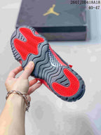 Close view of the outsole showing red traction sections, dark gray tread, and a patterned midfoot panel.