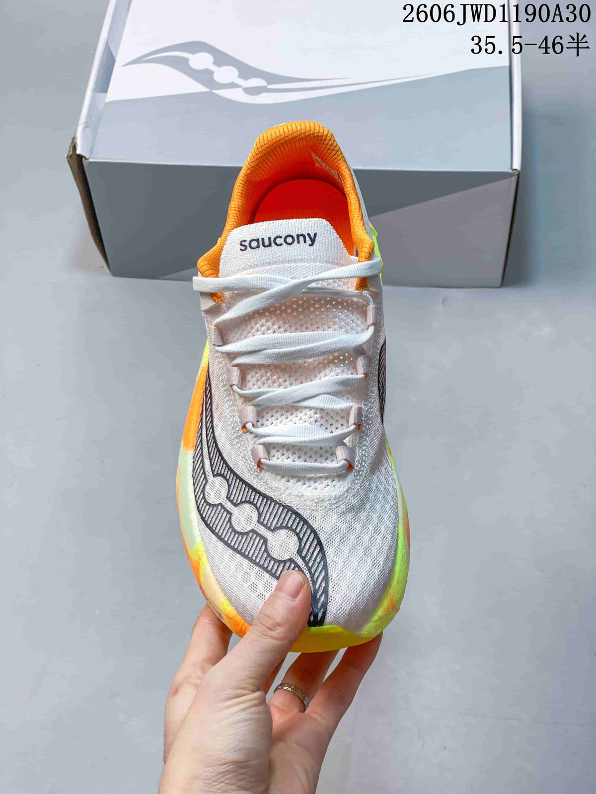 Top view showing the white lace-up upper, Saucony tongue branding, and orange collar.