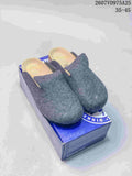 Pair of gray Birkenstock Amsterdam clogs displayed on a blue shoe box.