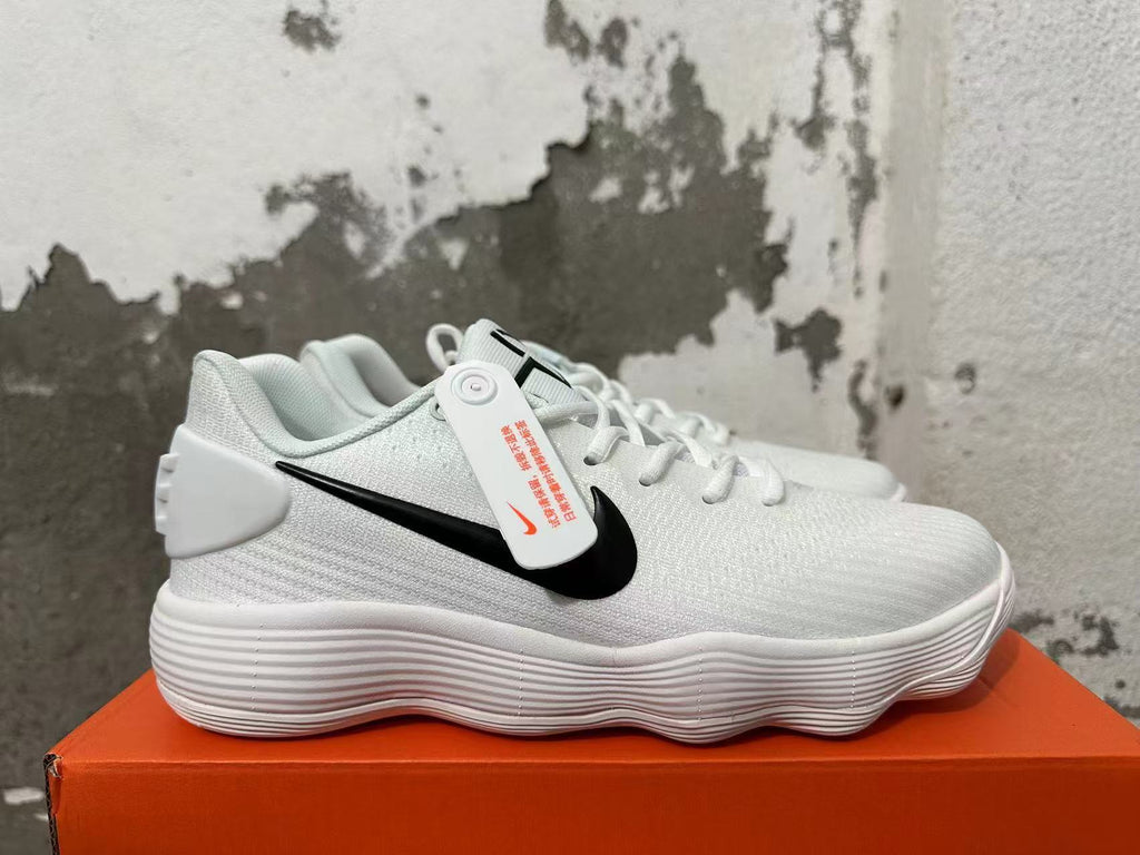 Side view of a white Nike shoe with a black Swoosh and ridged sole