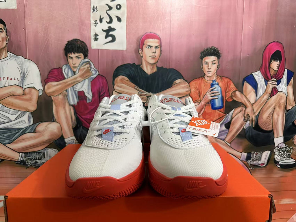 Front view of white and red Nike basketball shoes with lace-up uppers and perforated toe areas.