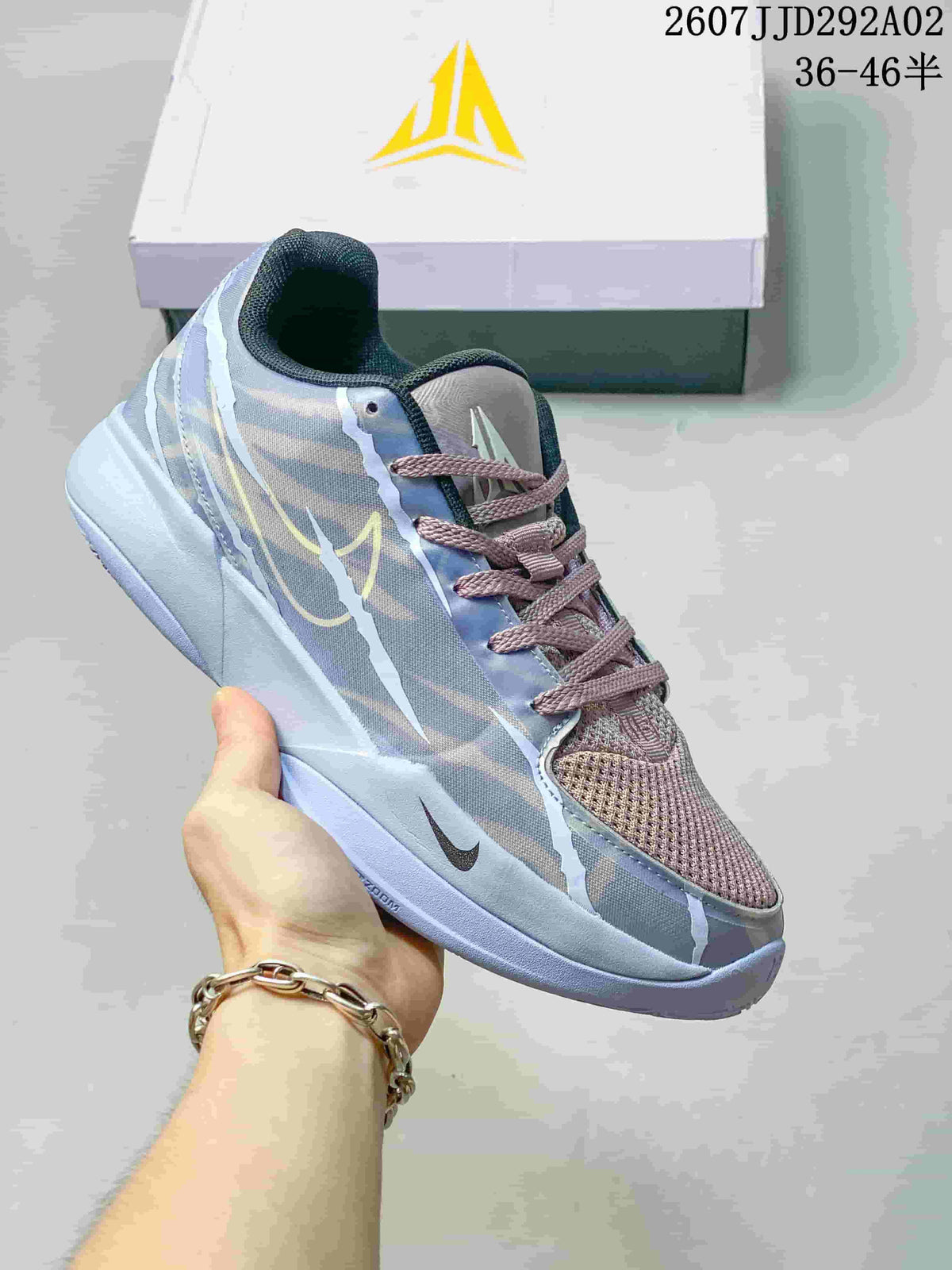 Grey and pale blue Nike JA 2 basketball shoe with a muted pink tongue and matching branded box.