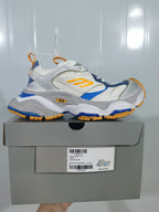 Side view of a New Balance 9174 sneaker displayed above its box; the box label shows EU size 40 and the color text WHT/GREY/ORANGE/BLU.
