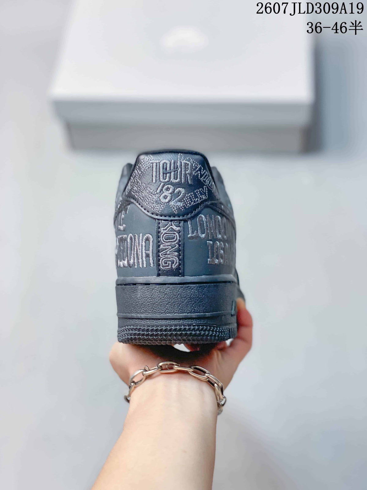 Rear view of the dark gray sneaker showing graphic lettering across the heel and a layered rubber sole.