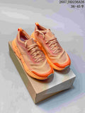 Pair of peach-orange On CloudSoma trail running shoes displayed on a shoebox.
