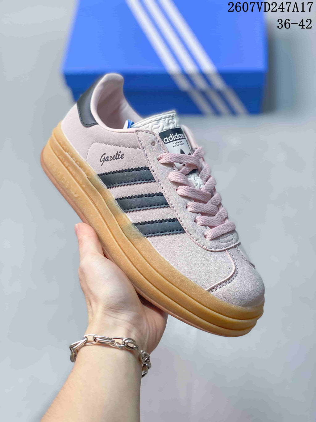 Angled side view showing Gazelle branding, black stripes, pink upper, and raised gum sole.