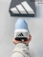 Rear view of the light blue shoe showing the white heel section, adidas logo, and black outsole edge.