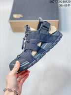 Side view of the black sandal showing layered adjustable straps, open side panels, mesh-like sections, and the rugged sole.