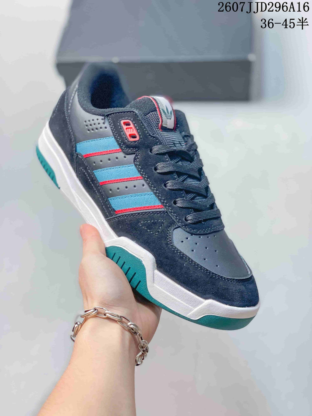 Angled side view showing the navy low-top silhouette, layered upper panels, colored side stripes, and contrasting outsole.