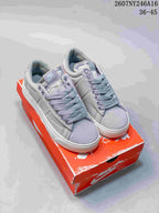 Pair of gray Nike Blazer Low sneakers displayed on a red Nike shoebox; code 2607NY246A16 and size range 36–45 are visible.