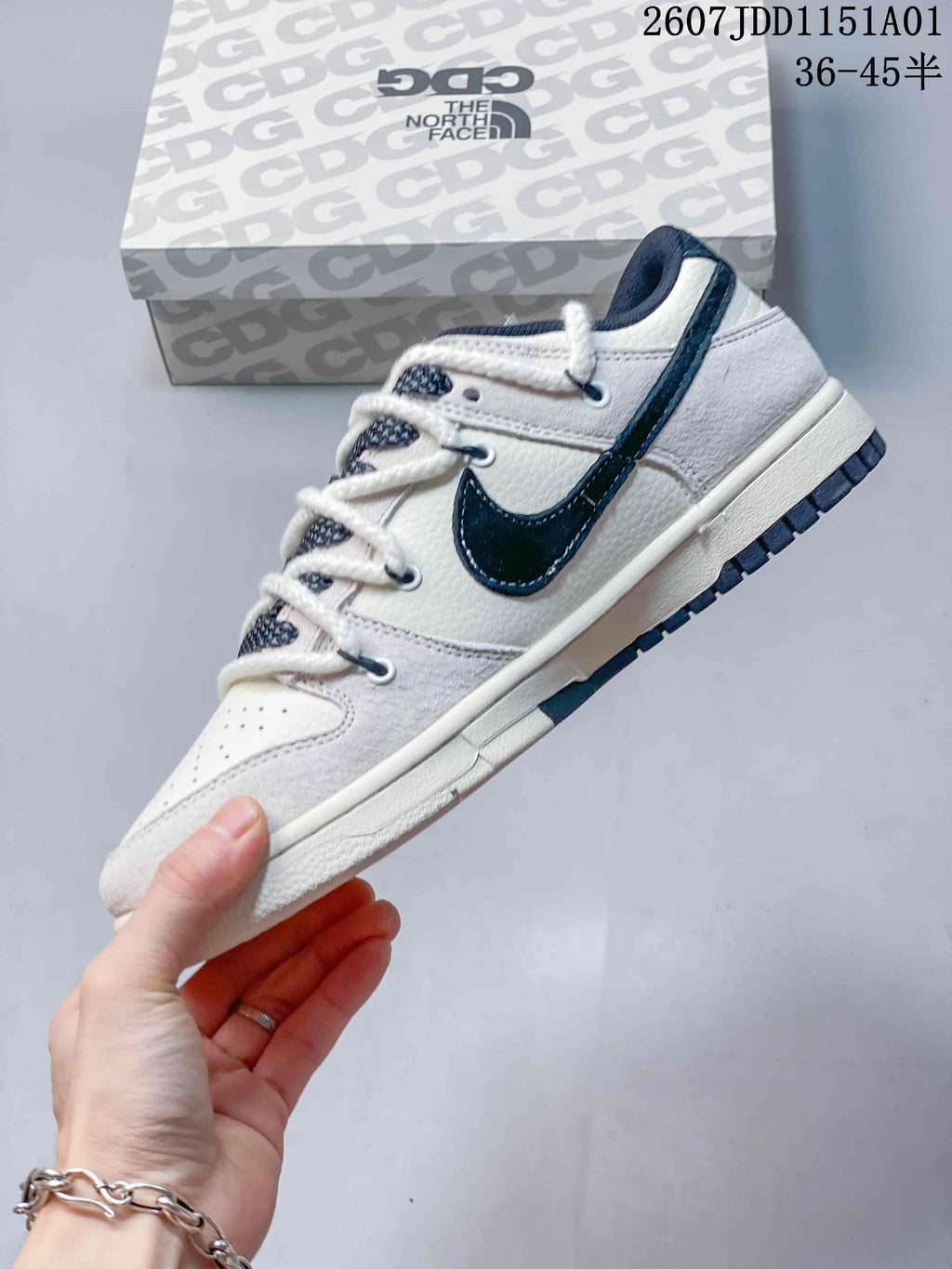 Side profile of an off-white low-top sneaker with a navy side logo and thick white laces