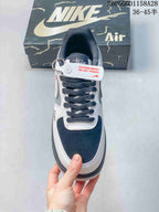 Top view showing a perforated navy toe panel, dark laces, and white overlays.