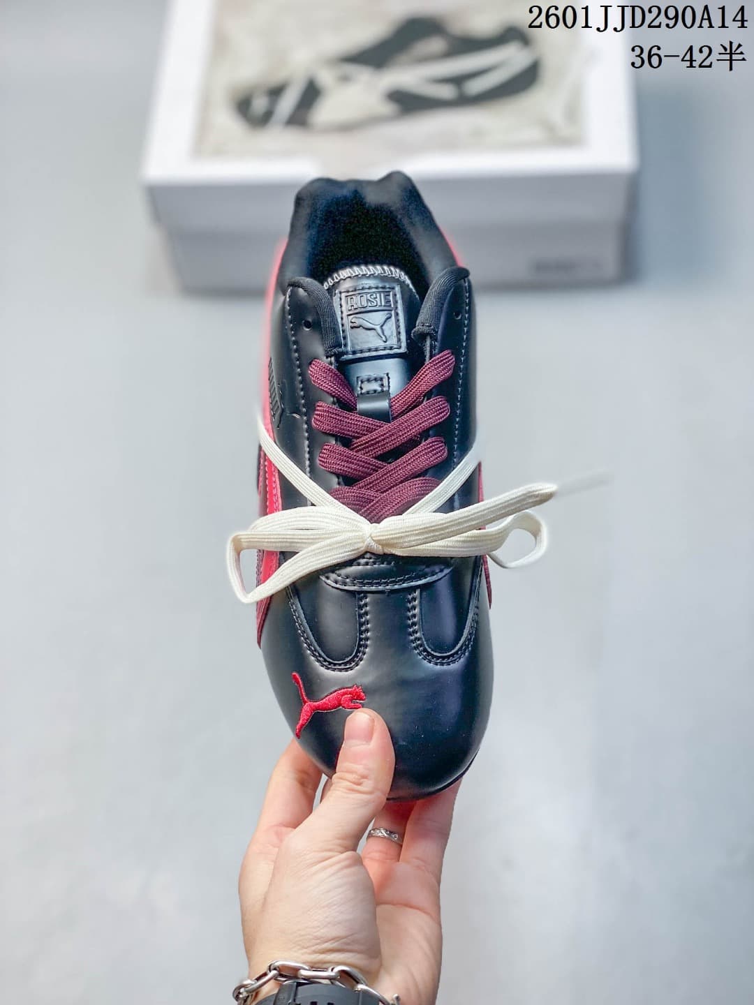 Top view showing the rounded black toe, burgundy laces, white laces, tongue branding, and red PUMA logo.
