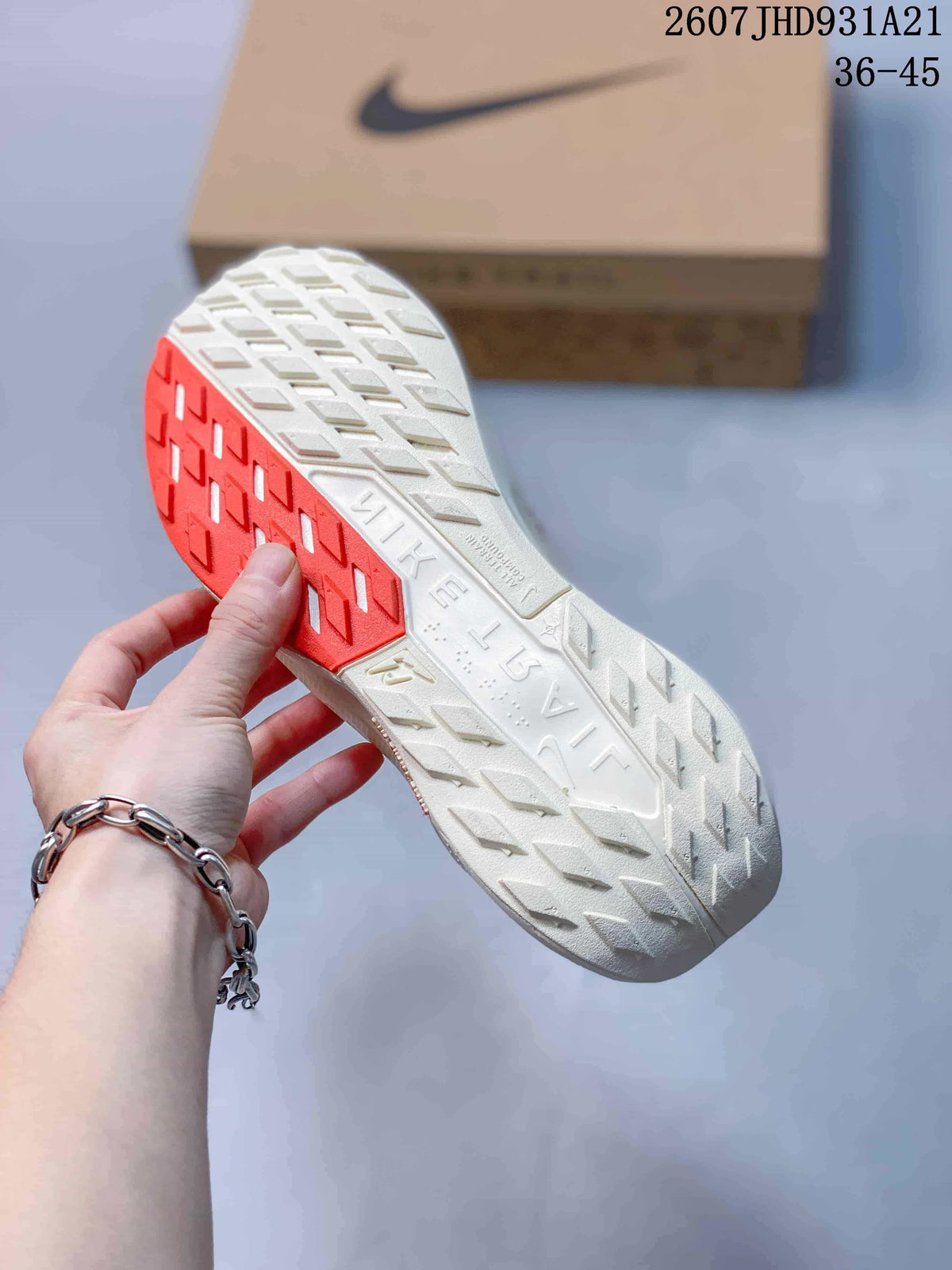 Bottom view of the sneaker showing a white and red patterned outsole with textured traction sections.