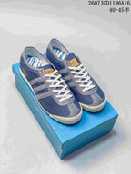 Pair of blue denim-style adidas Spezial sneakers displayed on a blue shoebox.