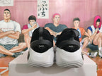Rear view of black basketball sneakers with white sculpted soles and heel pull loops.