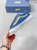 Side view of the blue low-top sneaker with a multicolor textured stripe and white rubber sole.