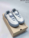 Pair of white and gray Descente low-top hiking sneakers displayed on a shoebox