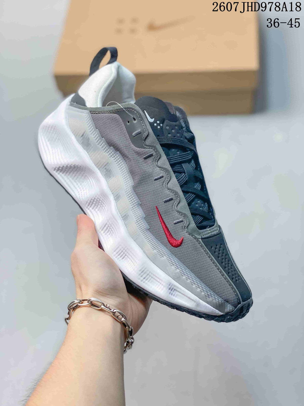 Angled side view showing the gray textile-looking upper, red Swoosh, padded heel, and layered white midsole.